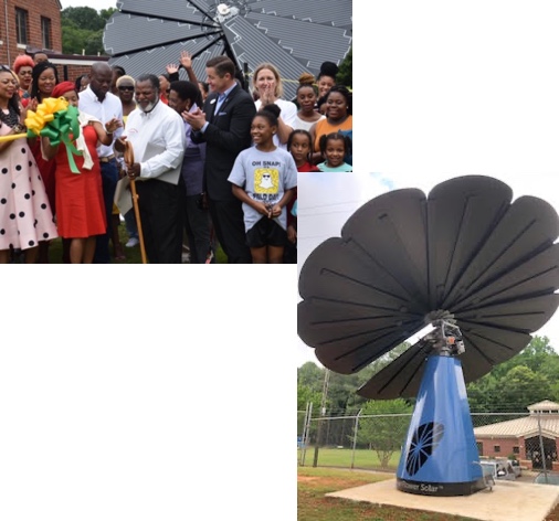 Group of people celebrating in front of a solar panel.